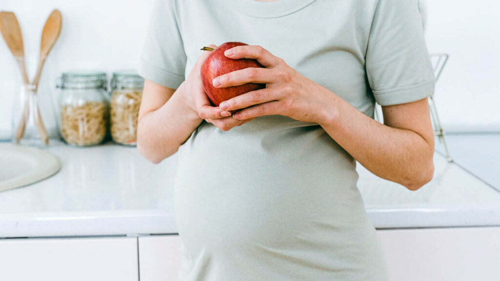 Pregnant woman holding an apple