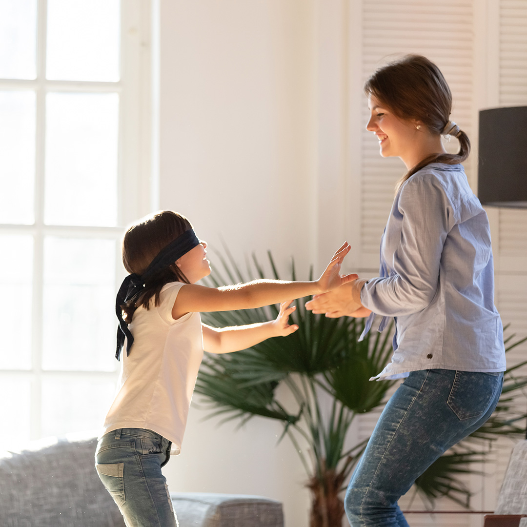 Blindfolded girl trying to catch mum Blindfolded girl trying to catch mum