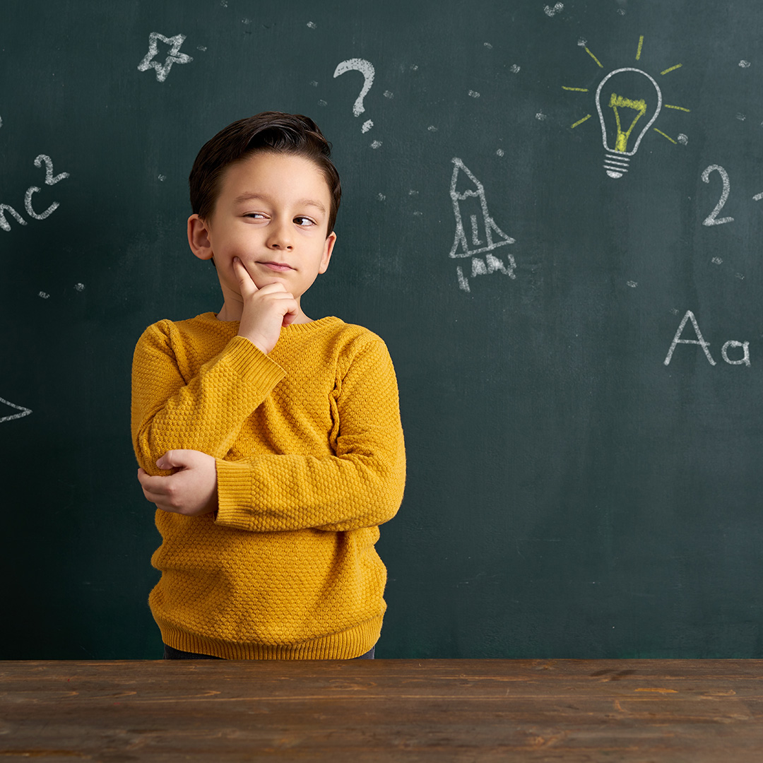 Child thinking with blackboard of ideas in background Child thinking with blackboard of ideas in background