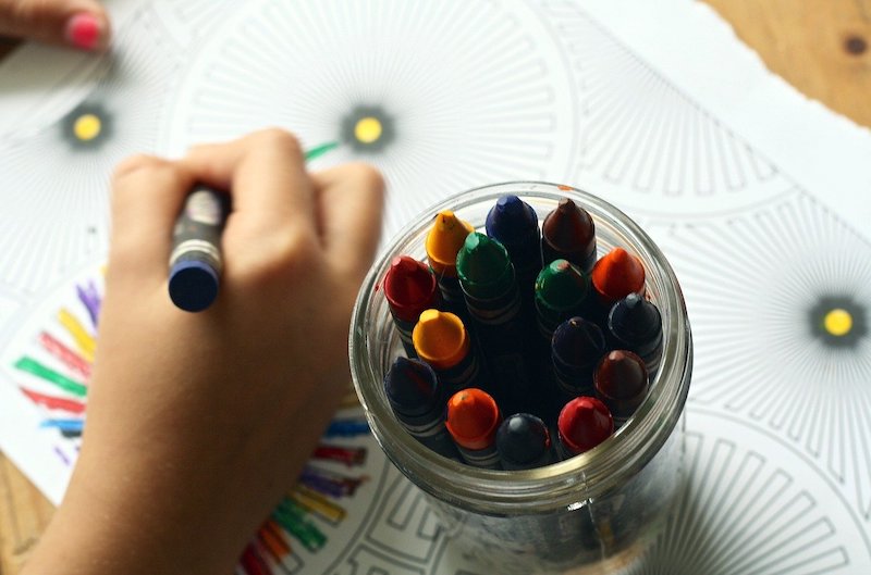 Child-with-jar-of-crayons-colouring-in Child colouring in activity to stay positive during lockdown