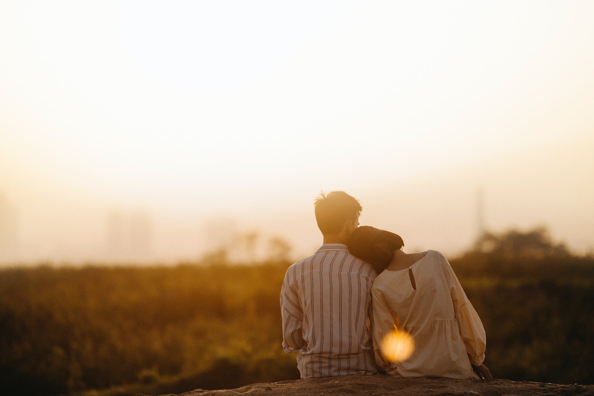 Back of man and woman watching sunset
