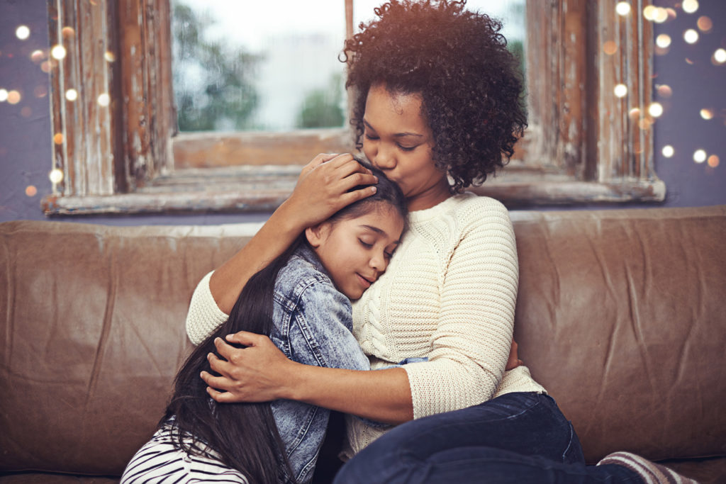 Mother hugging daughter, helping child cope with rejection