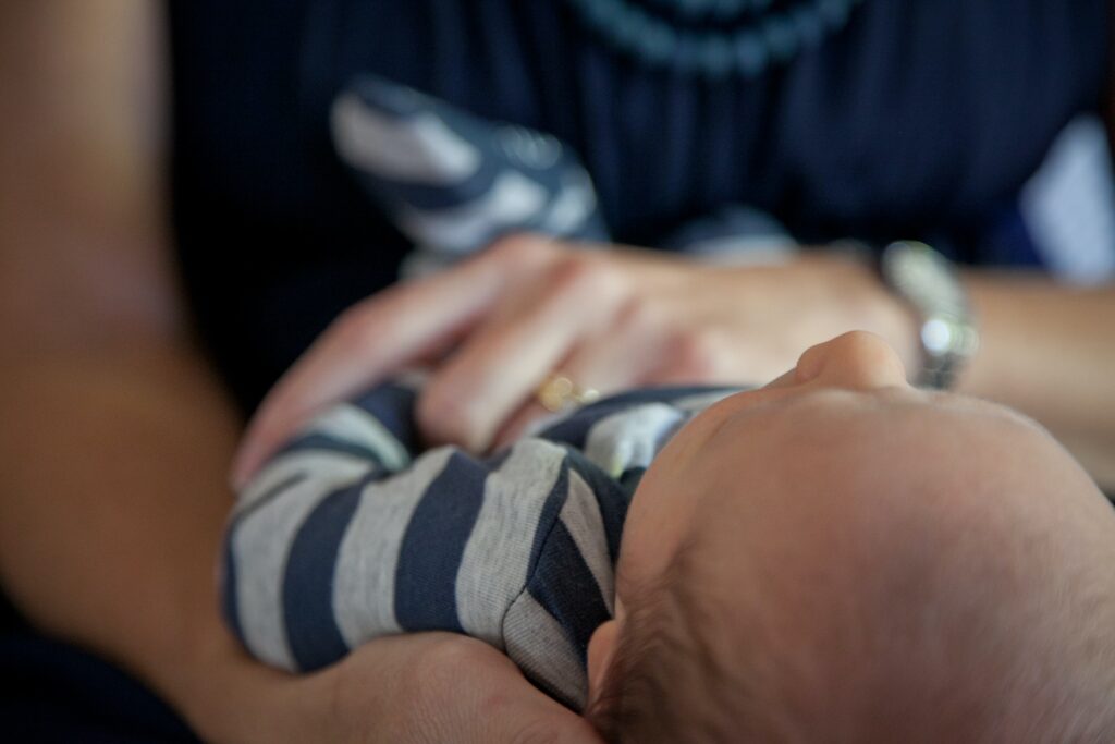 baby being held by an adult. view is of the baby's head