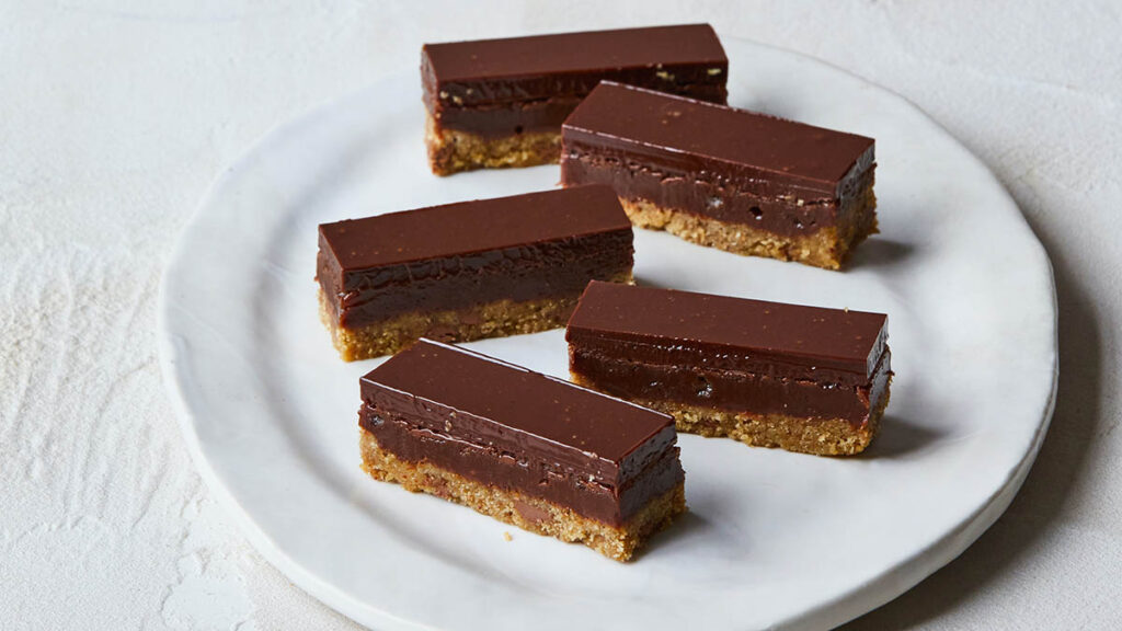 Four caramel slice on a white plate